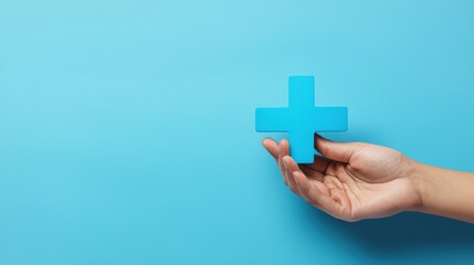 A hand holding a blue cross with a white star