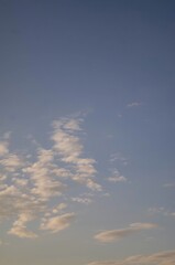 Morning sky in rural Ukraine with soft, scattered clouds against a clear blue background, capturing the peaceful beginning of a new day.