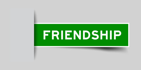 Green color square shape sticker label with word friendship inserted in gray background