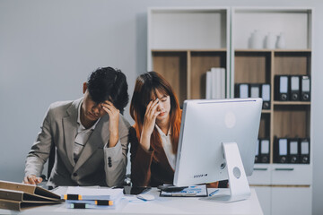 Stressed business couple working at big cabinet. Frustrated director closed face with hands at laptop workplace interior. Woman partner solving problems on smartphone call feeling nervous at office