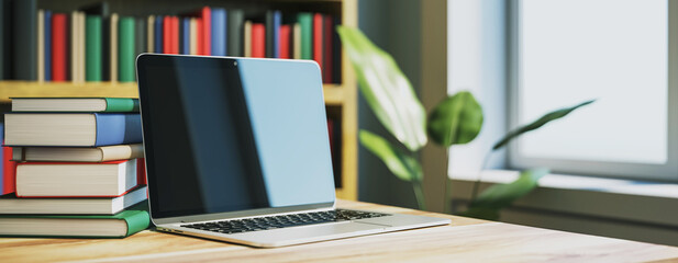 Laptop on wooden desk with stack of books in modern library room. 3D Rendering