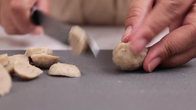 Female Hand SLicing Bakso or Beef Meatballs 