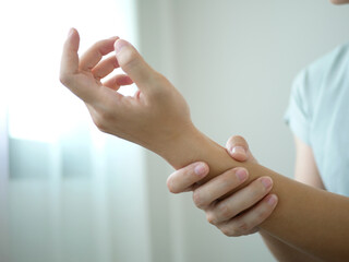 Obraz premium A young businesswoman suffered a wrist injury, numbness and pain from working too long. Health care and office syndrome concept