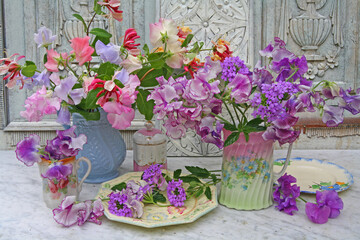 Pretty still life of flowers in jugs on a marble table