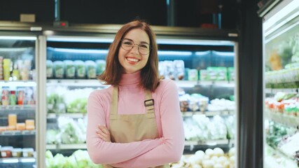 In a bustling market, a cheerful grocery employee in a colorful apron smiles while working hard to ensure customers have a delightful shopping experience with fresh, quality products