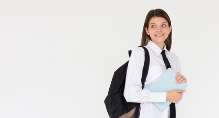 Young woman IT student wear white shirt backpack bag hold closed tablet looking aside on area isolated on white background. High school university college concept