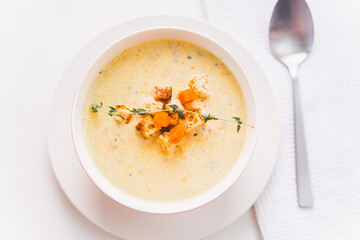 Cream soup with croutons and thyme in a white plate on the table. Selected focus. High quality photo