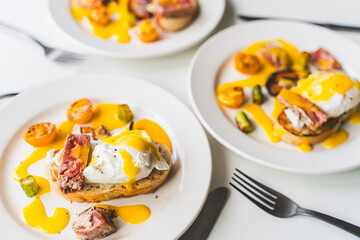 Plates of toast with egg benedict, tuna and hollandaise sauce on a white background. Selected focus. High quality photo