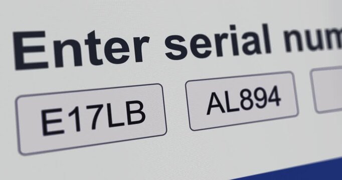 Typing a Serial Number into form, software activation process, entering product key, close-up screen field, footage