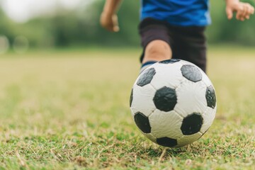 Fototapeta premium A scene of a child participating in a sports activity, like kicking a soccer ball, showcasing the development of physical coordination and teamwork