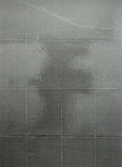 A sheet of crumpled paper with a gray tone, reflecting the texture and quality of an old-fashioned photograph. The background is dark gray to enhance its classic feel. 