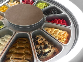 Colorful ice cream flavors display inside a fridge.