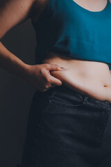 Naklejka premium fat woman, fat belly, chubby, obese woman hand holding excessive belly fat with measure tape, woman diet lifestyle concept