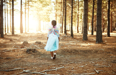 Forest, trees and back of child with wings for butterfly, adventure and imagination in nature. Enchanted, weekend and little girl with costume for outdoor fantasy, fairytale or magic journey in woods