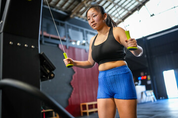 Woman training using lat machine to pull weights