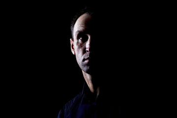 Brutal man in a black shirt on a dark background