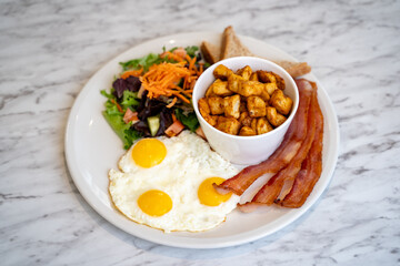 Breakfast plate with egg and bacon.