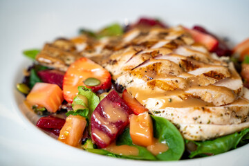 Healthy vegetable salad with grilled chicken breast.