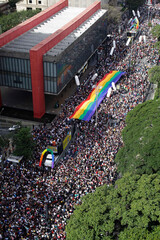 Revelers fill the streets holding a giant rainbow flag during the annual Gay Pride parade in...