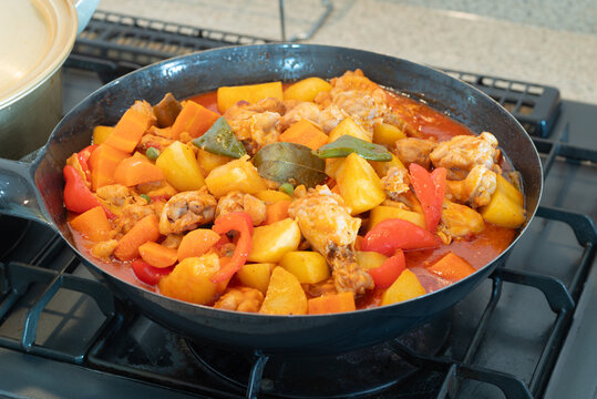 Freshly cooked chicken afritada in a kawali - a Filipino dish