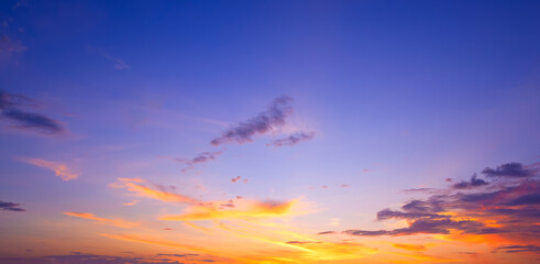 Dusk sky background with yellow orange sunlight and dark cloud on horizon blue evening sky in panoramic view, Beautiful idyllic natural tranquil scene