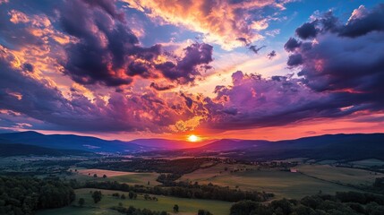 Amazing sunset with dramatic clouds illuminated in fiery colors above a peaceful rural landscape.