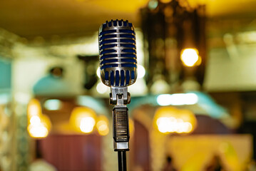 Vintage microphone on stand in a cozy café setting. A vintage microphone stands ready on a stand...