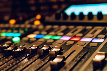 Close-up of a mixing console during a recording session at night. A recording studio mixing console...