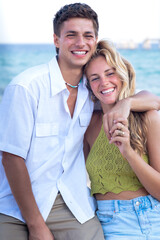 Vertical portrait two young friends on the beach looking at the camera