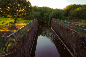 Wastewater treatment facilities and sewage systems surrounded by natural landscapes, blending industrial infrastructure with the environment