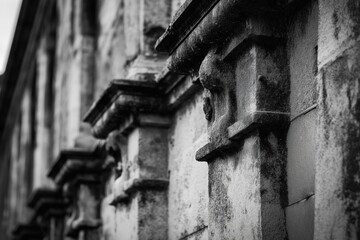 The image is a black and white photo of a building with stone pillars