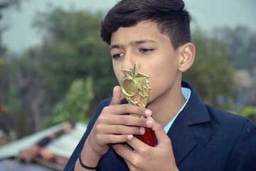 Indian handsome school boy with gold medal, school concept, selective focus