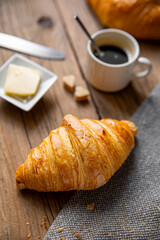 Croissant au petit déjeuner sur un plateau en bois.