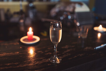 gasses of champagne in the dark with candles light. alcohol cocktails on a party. Party and holiday celebration concept.