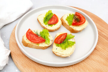 Bruschetta sandwich bread toast with cheese ricotta,fresh tomatoes,basil greenery on cutting board.Tasty healthy vegetarian food,Italian cuisine appetizer.top view flat lay