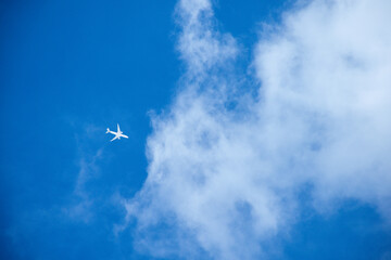 Airplane flying over blue sky bright and big cloud beautiful, Aircraft on clouds and gray rain clouds and clear blue sky background for the concept of tourism and travel 2025.