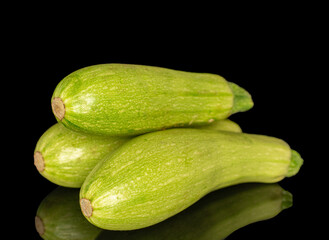 Three ripe zucchini, macro, isolated on black background.