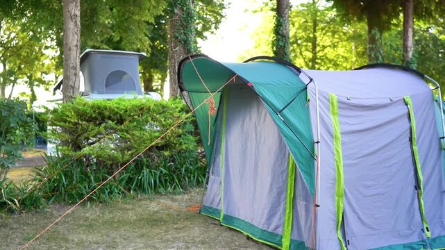 A smooth video showcases a spacious family tent set up in a picturesque natural setting. The tent, surrounded by greenery, embodies the essence of a family camping trip, highlighting the joys of outdo