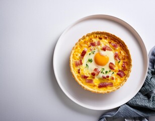 Quiche Lorraine pie with beechwood smoked bacon, creamy Cheddar cheese and free-range egg in shortcrust pastry on a white plate and modern white background. Flat-lay or top view banner with copy space