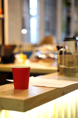 Paper cup of red coffee in a cafe on the table