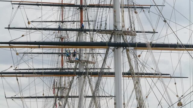 Cutty Sark rigging and masts.
Detail of the sailing ship Cutty Sark. Includes people up aloft doing maintenance work.
