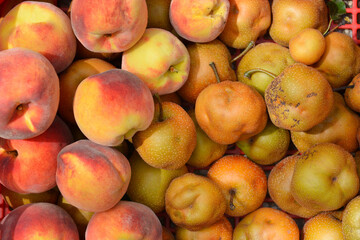 Detail of a pile of freshly picked peaches and Asian pears