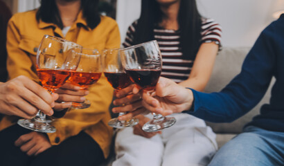 Happy friends making a toast with beer before eating pizza in a shared apartment.