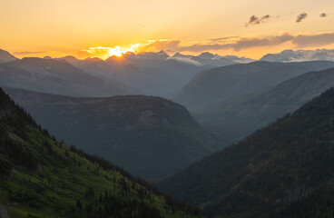 Fototapeta premium Clouds Hang On The Ridges Of The Continental Divide With Sun Burst In Late Evening