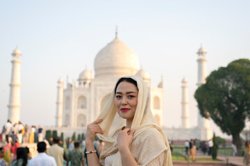 Agra, India, March 23, 2024. Portrait of an Asian woman with the Taj Mahal in the background.