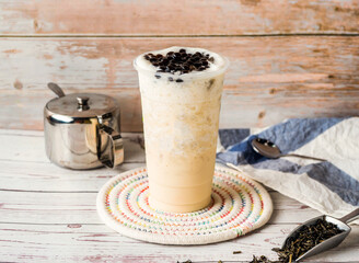 Iced Jasmine Tapioca Green Milk Tea with sugar pot and spoon served in disposable glass isolated on table side view of hong kong tea
