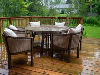 Outdoor veranda of house with brown wicker armchair and plants pots. Cozy space in patio or balcony with garland. Modern lounge outdoors in backyard.