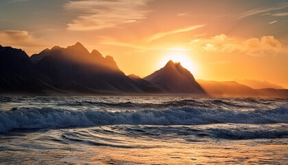 Naklejka premium Serene mountain range at sunset with waves in the foreground reflecting nature's magnificence and beauty