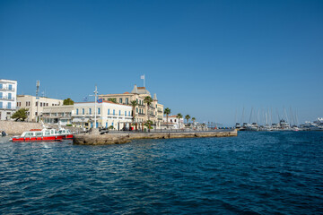 Spetses island, Greece. Seafront buildings and motor boats taxis at small port of Dapia