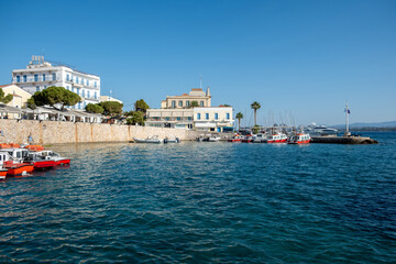 Spetses island, Greece. Seafront buildings and motor boats taxis at small port of Dapia